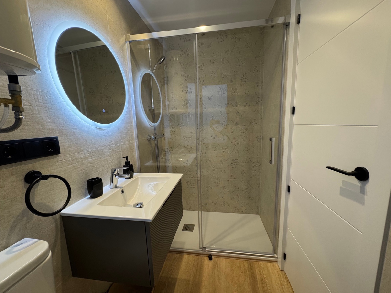 Baño con ducha y espejo redondo