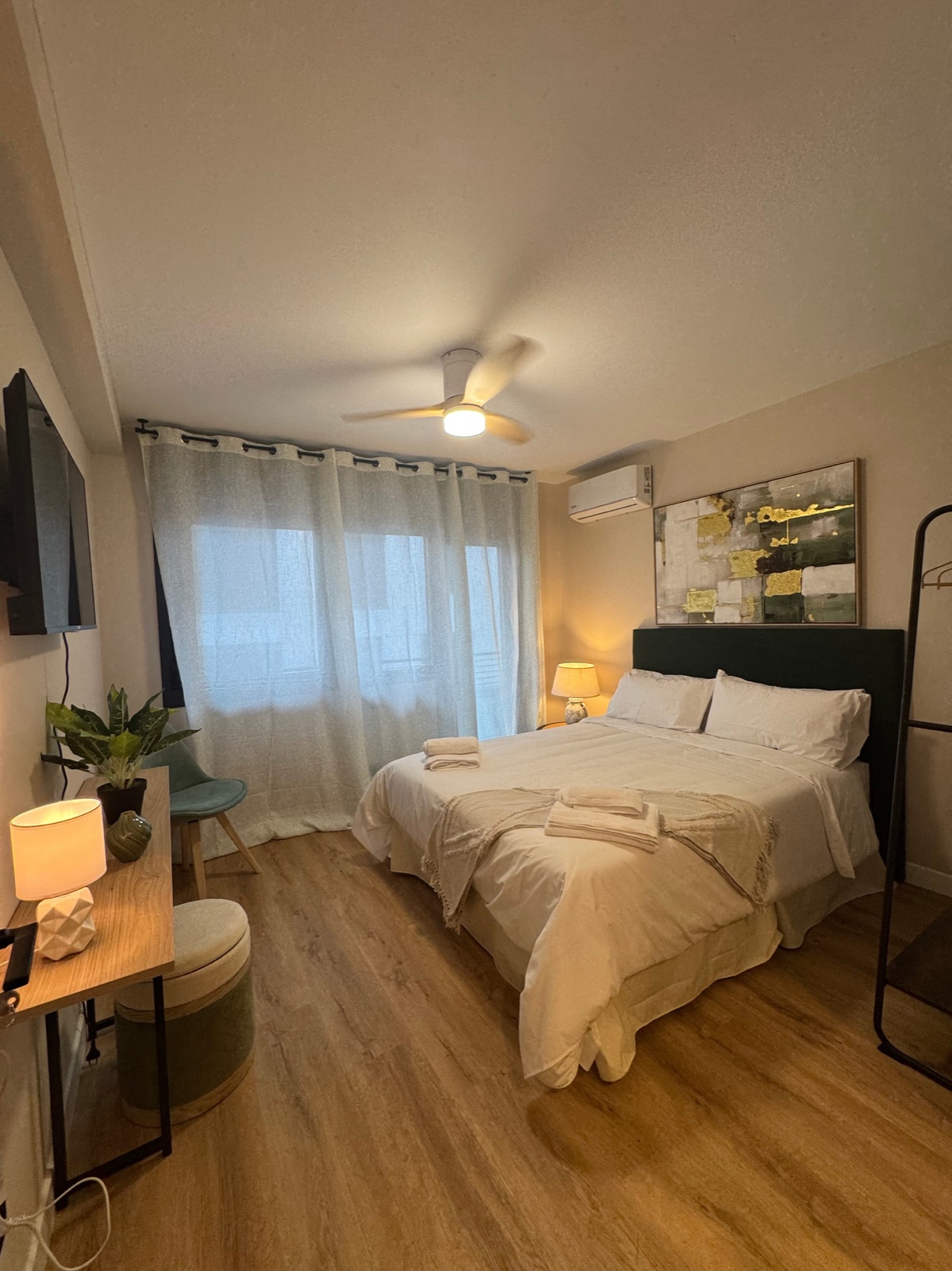 Dormitorio de una suite con cabecero verde y arte dorado