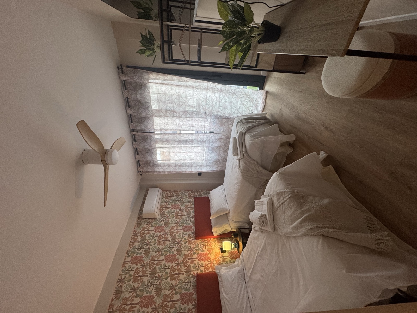 Habitación con dos camas individuales, papel pintado botánico y salida a la terraza